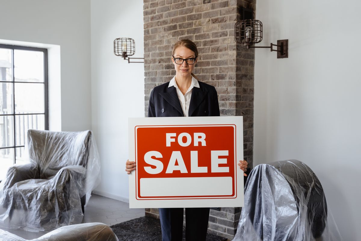 A property manager standing outside a house with a clipboard, making a routine visit