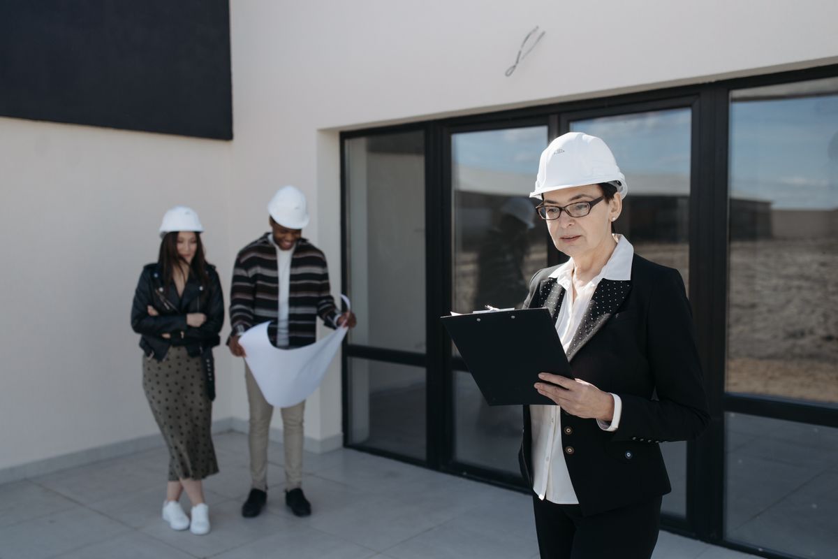 Two professionals reviewing building plans on site