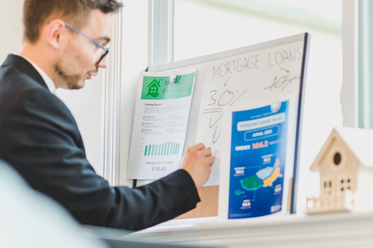 A business owner reviewing paperwork on a whiteboard with a client