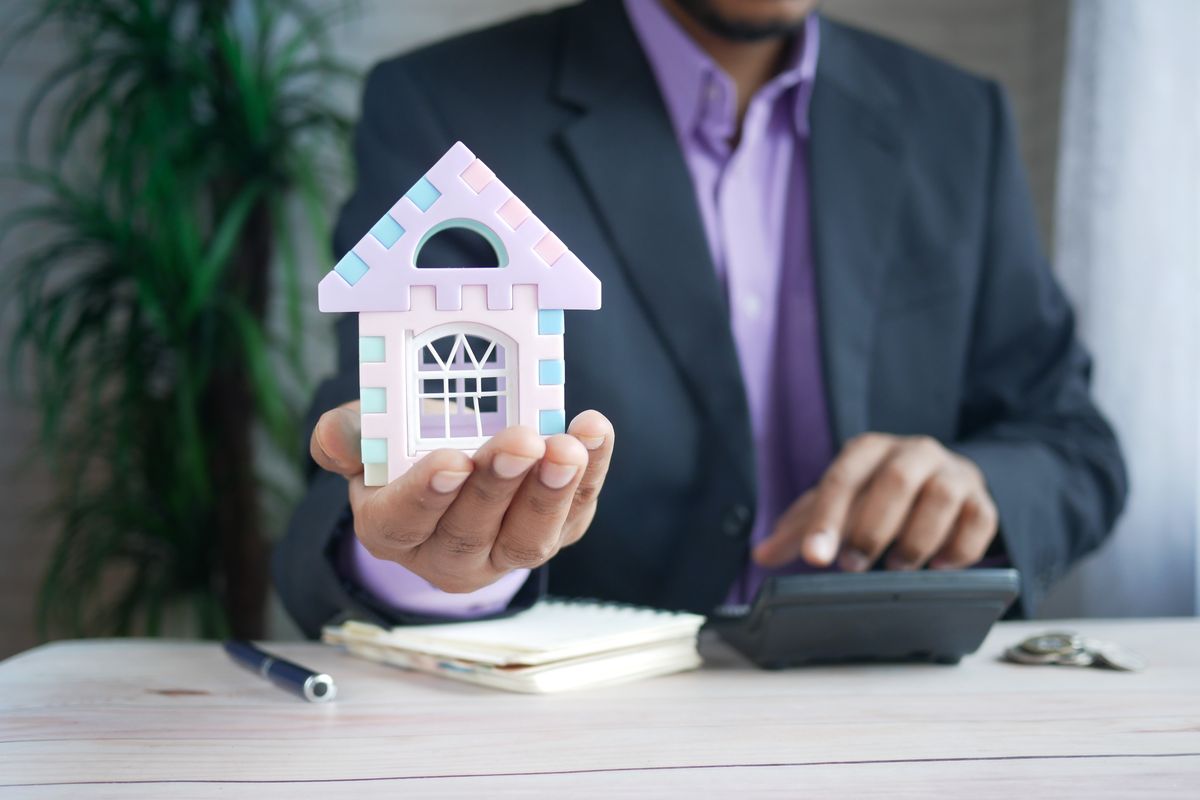 A professional reviewing a small model house while planning next steps