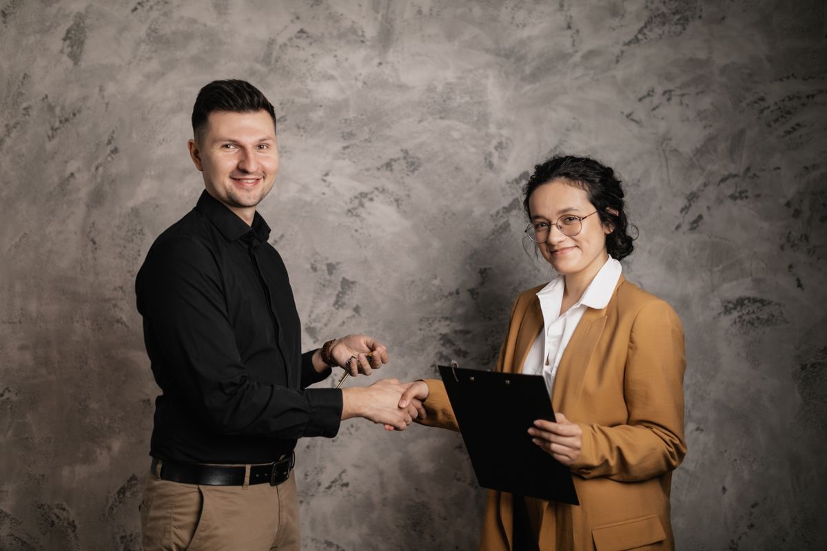 A real estate agent shaking hands with a client in a bright home