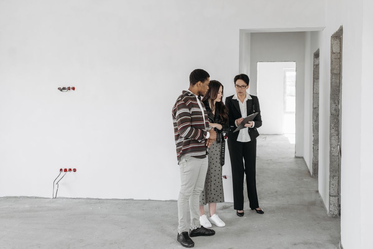 A real estate professional and clients reviewing paperwork together