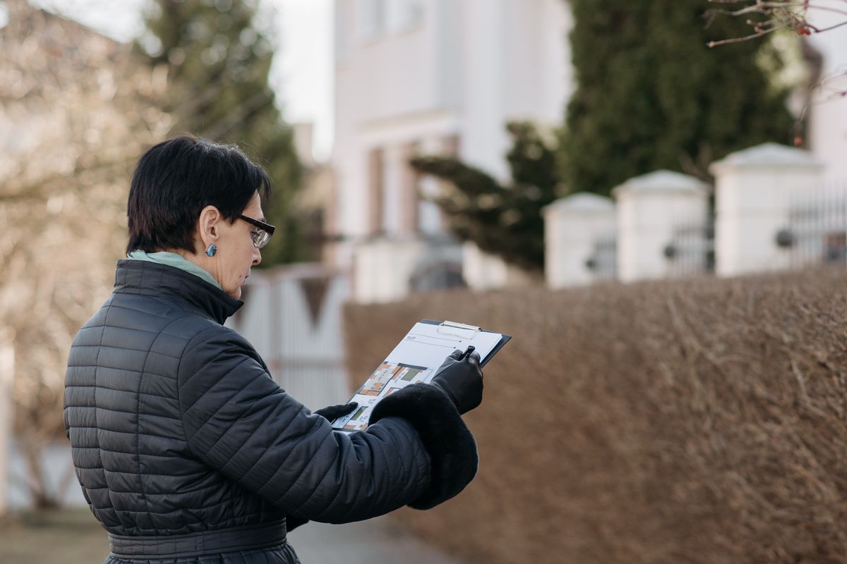 A manager documenting the condition of a property with a camera and notes
